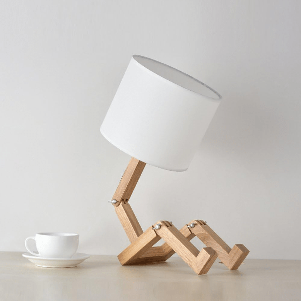 Lampara noche robot junto a una taza de café 